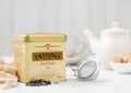 LONDON, UK - OCTOBER 21, 2020: Steel jar of Twinings Earl Grey loose tea with iron teapot and strainer infuser on white