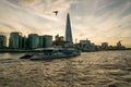 LONDON, UK - October 17th, 2017: The Shard building view from Thames riverside with river cruising ships in view, sunset