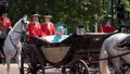 Queen Elizabeth II travels along The Mall in an open carriage pulled by horses, on her way to the Trooping of the Colour parade.