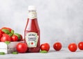 LONDON, UK - SEPTEMBER 13, 2018: Heinz ketchup with fresh raw tomatoes in box on wooden background. Royalty Free Stock Photo
