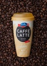 LONDON, UK - SEPTEMBER 09, 2020: Plastic cup of Emmi Caffe Latte skinny iced coffee inside fresh raw coffee beans