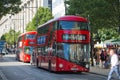 Red British double decker buses and taxis in Oxford street, the main destination for shopping in West End London. Modern life and