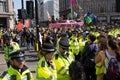 Metropolitan police officers surround Extinction Rebellion protesters and pink boat at Oxford Circus, London.