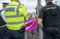 Police officers monitoring Extinction Rebellion protesters at Trafalgar Square London UK.