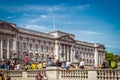 London UK Tourists sit on wall in front of Bukingham Palace waiting to see the changing of the guard -sometaking