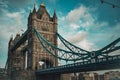 Tower Bridge in a dark blue sky with birds flying by and pedestrians and vehicles Royalty Free Stock Photo