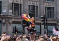 Woman climbs up traffic light pole at Oxford Circus, London, to get a better view of the Gay Pride Parade.