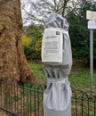 London, United Kingdom - April 03, 2020: Drinking fountain in Lewisham park covered with gray plastic foil, sign informing about