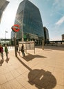 London, United Kingdom - April 06, 2007: Sun shines on underground sign at Canary Wharf station, people walking by, tall. Royalty Free Stock Photo