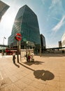 London, United Kingdom - April 06, 2007: Sun shines on underground sign at Canary Wharf station, people walking by, tall Royalty Free Stock Photo