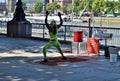 A dark-skinned male street performer or busker, next to river Thames in London