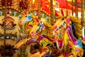 Three horses in line on an empty colourful carousel in London, UK.