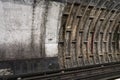 London, United Kingdom - February 02, 2019: Old dirty wall in tube train tunnel, missing London Underground logo on concrete