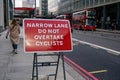 London, United Kingdom - February 02, 2019: Red road sign prompting not to overtake cyclists because of narrow road in busy city Royalty Free Stock Photo