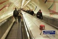 London, United Kingdom - February 01, 2019: Riding down the escalator in London tube, commuters in winter clothes on both sides