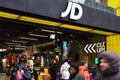 London, United Kingdom - February 01, 2019: White J D letters logo on their Oxford street branch, pedestrians walking in front. JD