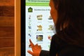 London, United Kingdom - February 01, 2019: Woman ordering food on large touch screen display at one of McDonalds branches, Royalty Free Stock Photo