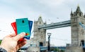 Revolut, Starling, Monzo bank cards hold in hand and London Tower Bridge at the blurred background. Conceptual: the competing fin