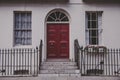 LONDON, UNITED KINGDOM - Jun 06, 2015: London. England. June, 6, 2015: typical red door in white building in london Royalty Free Stock Photo