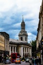 Clock tower of St Alfege Parish church, Royal Borough of Greenwich in London behind a common houses.