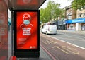 London, United Kingdom - June 06, 2020: Light ad at Lewisham bus stop prompting passengers to wear protective virus face mask in Royalty Free Stock Photo