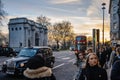 Double decker bus, hackney carriage taxi and pedestrians with Marble Arch