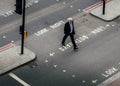 High perspective view of middle aged City of London middle aged officer worker crossing the street