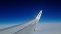 London, United Kingdom, March 24, 2024: Ryanair Plane Wing Soaring Above Clouds in Clear Blue Sky