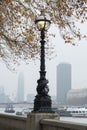 LONDON, UNITED KINGDOM - NOVEMBER 23, 2018: Misty. View of the Thames and ancient streetlight Royalty Free Stock Photo