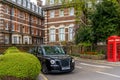 LONDON, UNITED KINGDOM - 22.04.2022: A residential street in south east London with a typical London taxi cab and red Royalty Free Stock Photo