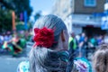 Back view of a senior female with a red flower hairband at the Hackney Carnival in London, UK