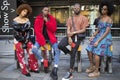 A group of fashionably dressed friends chatting at the entrance to the building