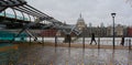 London in the winter rain. Millennium Bridge & St Paul`s Cathedral