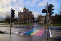 LONDONDERRY - NORTH IRELAND - JANUARY 01-2022 zebra crossing painted in LGBT flag colors, concept pride month, and Guildhall in