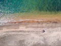 A lone beach umbrella on the sand beach, flat aerial view for background