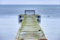 Lone bench facing a melancholic Baltic Sea on a fragile boardwalk conveys isolation, sadness and melancholy feelings. Dragor