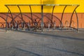 A lone bicycle standing in a bicycle parking near the yellow wall on a sunny summer day