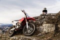 A lone bike, the Eneduro motorcycle stands next to the rock against the backdrop of the city of Pyatigorsk in the