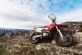 A lone bike, the Eneduro motorcycle stands next to the rock against the backdrop of the city of Pyatigorsk in the