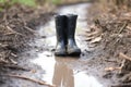 a lone black rainboot in the middle of a muddy path Royalty Free Stock Photo