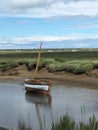 Lone boat on calm water, Blakeney, North Norfolk coast, East Anglia UK