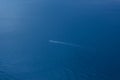 A lone boat in the endless blue sea. Top view of the sea background with the ship