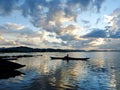 A lone boatman crossing beautiful Lak Lake, Central Vietnam at dusk Royalty Free Stock Photo