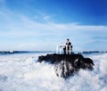 Lone business man working on a remote rock