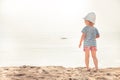 Lone child baby on beach looking into the sea horizon bright sunlight childhood lifestyle summer beach holidays background copy s Royalty Free Stock Photo