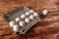 A lone egg is thrown near a package of eggs on a wooden table Royalty Free Stock Photo