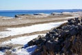 Lone explorer on a snowy rocky shoreline on a winter lake