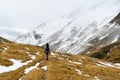 Lone female traveler hiking in the snow with a backpack. Winter snowy mountains in Pyrenees