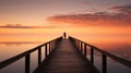 Lone figure standing on a long pier wooden at sunset