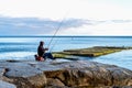 October 6 2019 Yalta, Crimea, Massandra beach. a lone fisherman with a fishing rod sits on a rock by the sea. Active rest on the B